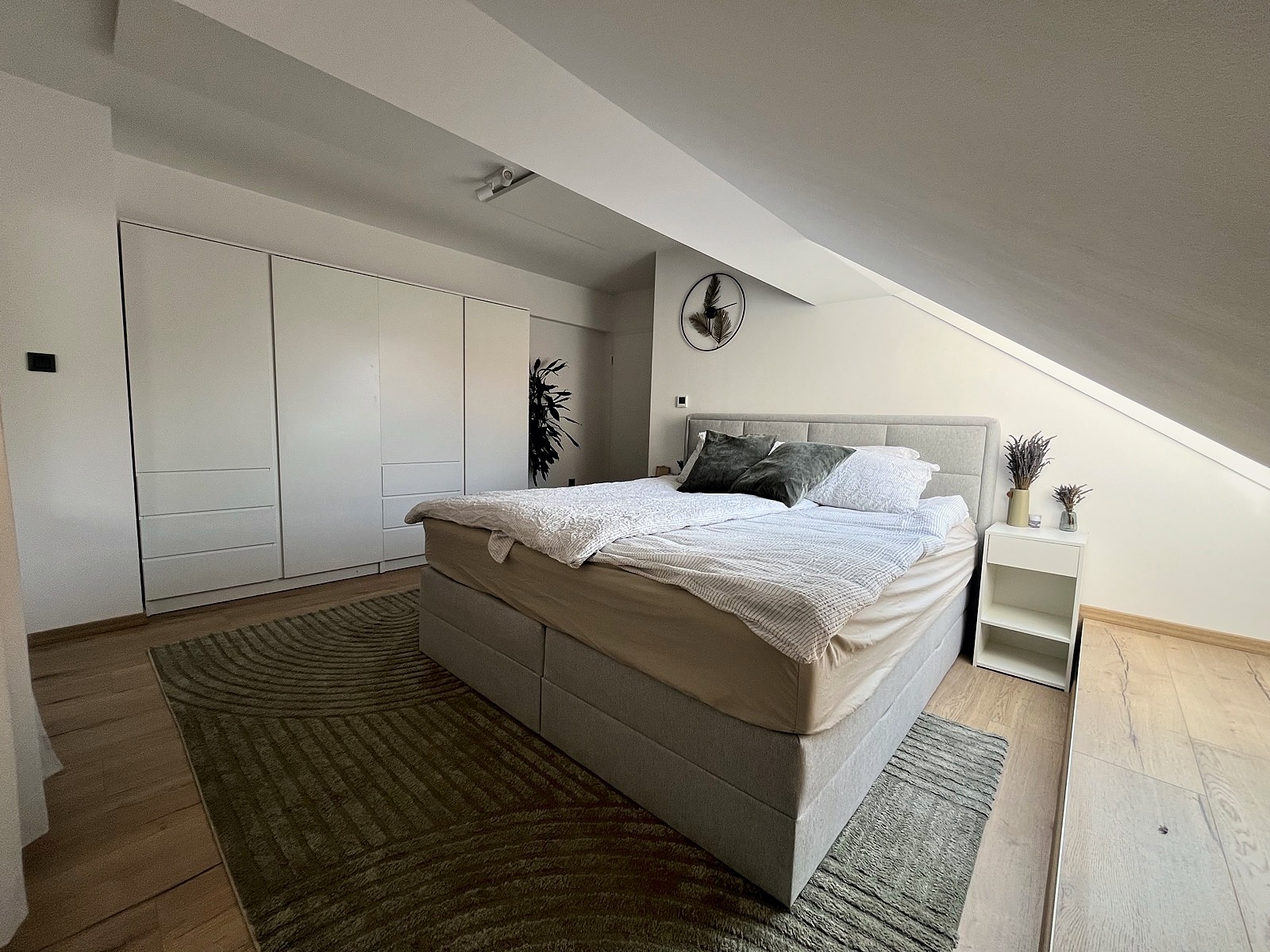 The main bedroom with a queen bed and built-in wardrobe under the eaves